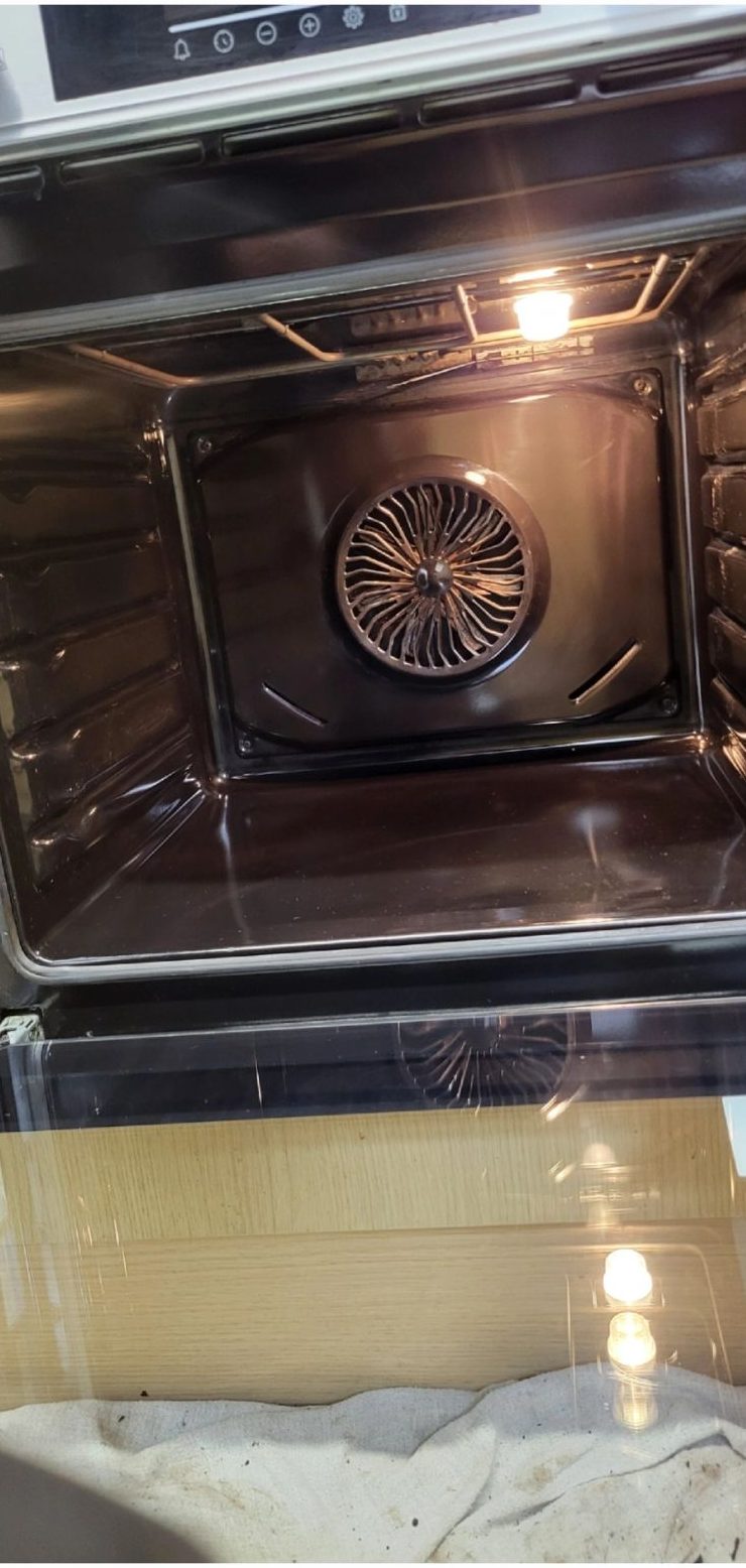 The same oven after cleaning, lit from inside and spotless
